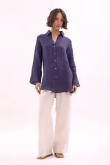 Camisa de lino color azul oscuro, de manga larga y corte holgado, con cuello camisero y cierre frontal de botones.