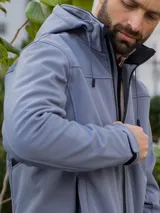 Campera gris con capucha, cierre frontal con cremallera y bolsillos laterales con cierre.