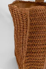 Cartera tipo shoulder bag de tejido trenzado en color marrón, con doble asa de hombro y forro interior a tono.