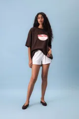 Remera oversize color crema con estampa central circular en color rojo que incluye el texto 'Chill Peel'. Presenta cuello redondo y mangas cortas con un ajuste holgado.