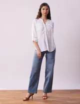 Blusa blanca de lino y rayón, marca Dash. Tiene cuello a la base, escote en V y abertura con botones. Cuenta con bolsillos en la parte delantera y mangas largas regulables con presilla y botón.