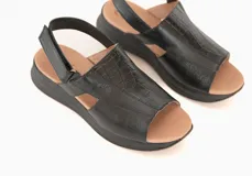 Sandalias de cuero negro con plataforma baja y tira trasera ajustable.