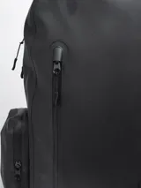 Mochila negra impermeable de estilo moderno y estético, con diseño opaco. Cuenta con compartimento principal con funda acolchada para computadora, varios bolsillos organizadores internos y bolsillos externos con cierre a los lados. Incluye correas ajustables con broche frontal para mayor estabilidad.