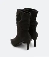 Bota de caña media color negro, con puntera fina, taco alto y textura símil gamuza.