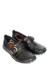 Zapato bajo de cuero negro con hebilla dorada.