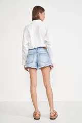 Short de jean celeste claro con efecto desgastado, tiro medio y ruedo deshilachado. Incluye un llavero con la inicial 'M' en el pasacinto y un forro de bolsillo con estampado de monograma.