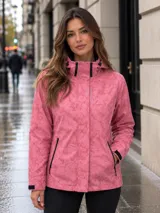 Campera cortaviento impermeable y transpirable de la marca Uniteduy. Presenta un diseño estampado en tonos rosados, con capucha ajustable, cierre frontal con solapa y bolsillos laterales con cierre. Es una prenda ultraliviana ideal para actividades al aire libre.