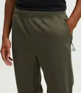 Pantalón deportivo de corte ajustado, confeccionado en tejido de poliéster texturizado color negro. Presenta cintura elástica con cordón de ajuste, bolsillos laterales con cierre y puños elásticos en los tobillos.