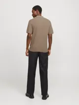 Polo de punto estructurado color greige, con cuello clásico, cierre frontal de dos botones y mangas cortas con terminación acanalada.