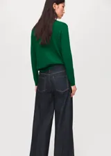 Jersey de punto fino color verde, con cuello redondo y diseño recto de manga larga.