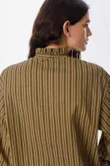 Camisa de manga larga con estampado de rayas verticales en color bordó y blanco. Presenta un cuello alto con volados y cierre frontal con botones a tono.