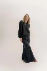 Pantalón de jean color beige, de tiro medio, corte amplio y ruedo acampanado.