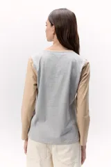 Remera de algodón de mangas largas, con cuerpo blanco, mangas color beige y laterales color gris.