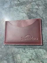 Tarjetero de cuero con diseño animal print en el frente y cuero liso marrón oscuro en la parte posterior, con compartimentos para tarjetas en ambos lados.