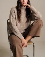 Sweater de punto con textura acanalada, cuello alto y diseño holgado de corte oversize.