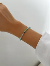 Pulsera de cristalitos facetados en tonos celestes, verdes y blancos con cuentas metálicas oscuras.