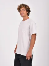 Remera blanca de manga corta con cuello redondo y un bolsillo simple en el pecho.