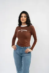 Remera de manga larga ajustada al cuerpo, color negro con cuello redondo blanco y franjas blancas laterales en las mangas. Presenta un estampado frontal con la inscripción 'Los Angeles' y una estrella pequeña.
