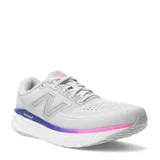 Championes New Balance Evoz Fresh Foam para mujer, color gris claro, con detalles en fucsia y violeta en la entresuela. Presentan el logo 'N' en los laterales y tecnología Fresh Foam.