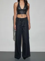 Jean azul oscuro de corte wide leg y tiro alto, con costuras pespunteadas verticales al frente y cinturón incorporado con hebilla cuadrada.