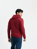 Sweater deportivo con capucha, bolsillo canguro frontal y cordones de ajuste. Presenta un diseño de color azul oscuro con interior de capucha en color verde.