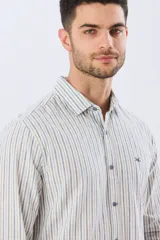 Camisa de manga larga de lino y algodón, con diseño de rayas verticales en tonos celestes y blancos. Presenta cuello camisero, cierre frontal con botones y pequeño bordado al tono en el pecho.