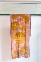 Pañuelo rectangular de seda natural color rosa con estampado de hojas de catalpa en tonos ocre.