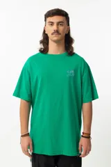 Remera verde con estampado de estilo caricaturesco en blanco y violeta.