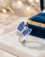 Anillo de plata 925 con diseño de mariposa, con alas superiores decoradas con piedras azules cuadradas estilo zafiro y alas inferiores pavimentadas con circonias brillantes.