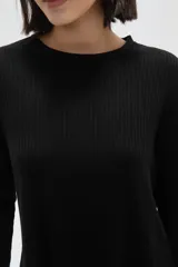 Remera de manga larga con cuello a la base, confeccionada en tejido de punto canalé con diseño holgado.