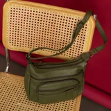 Bandolera morral color verde militar en símil cuero, con dos bolsillos frontales con cierre, doble apertura superior con cierre y un bolsillo trasero con cierre. Incluye dos bolsillos internos y correa de galón larga regulable.