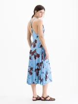 Vestido midi celeste de viscosa con estampado de corazones formados por cadenas y candados en tonos marrones. Presenta escote redondo, hombros descubiertos, espalda abierta con tiras cruzadas y silueta evasé.