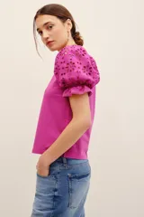 Remera fucsia con mangas abullonadas de broderie estilo globo, con cuello redondo y diseño liso en el cuerpo.