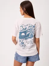 Remera manga corta de algodón color blanco, con calce holgado y gran estampado en la espalda de temática playera en tonos azules.