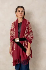 Cinturón trenzado de textura gamuzada con hebilla metálica circular grande y ornamentada.