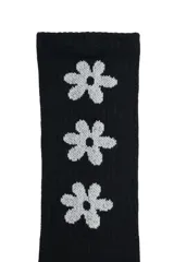 Medias de caña larga color negro, con diseño acanalado y estampado de flores blancas en el lateral. Presentan detalle de línea blanca en la puntera y logo de la marca estampado en el empeine.