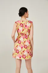 Vestido corto con estampado floral en tonos amarillo, rosa y rojo, con escote redondo, sin mangas y cintura elastizada con lazo.