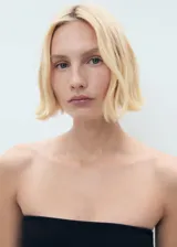 Top negro de corte peplum y escote palabra de honor, sin mangas.