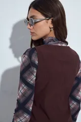 Chaleco sastrero color bordó con escote en V y cierre frontal con botones. Presenta un diseño entallado y estructura clásica.