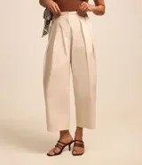 Pantalón carrot color beige confeccionado en tricolina con efecto empapelado, cierre tradicional y pliegues.