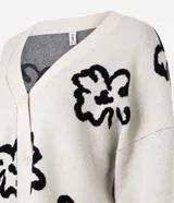 Cardigan color crema con estampado de flores abstractas en negro, escote en V, cierre frontal con botones y mangas largas.