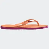 Ojotas Havaianas modelo Slim Point, con suela y tiras más finas, punta ligeramente puntiaguda y borde contrastante. Las tiras son de color lila claro con el logotipo de Havaianas en metalizado. La suela es lila claro con borde exterior en color terracota/rosado oscuro.