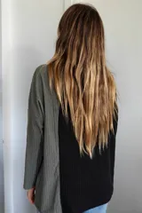 Polerón de cuello alto con diseño bicolor en negro y verde oliva. Confeccionado en tejido de punto acanalado, presenta un corte holgado y asimétrico con mangas largas.