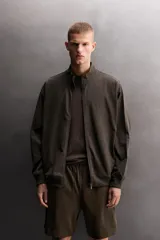 Sudadera relaxed fit gris claro melange de tejido ligero con mezcla de algodón, cuello subido, manga larga y cierre frontal con cremallera. Cuenta con bolsillos laterales ocultos y acabados en rib.