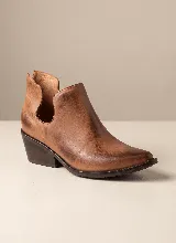 Botín de cuero vacuno color negro, con diseño de corte lateral y taco cuadrado de 5 cm. Presenta punta fina y suela de caucho antideslizante.