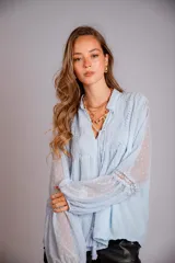 Camisa celeste de plumetí con cuello mao, mangas globo largas con puños elásticos y lazo en el escote.
