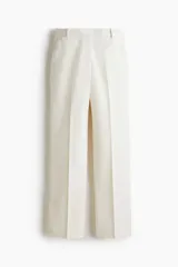 Pantalón sastrero color blanco, de tiro alto y corte recto, con pinzas y bolsillos laterales.