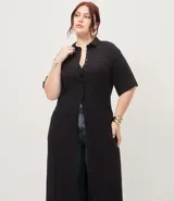 Vestido chemise largo negro, confeccionado en viscosa, con cuello camisero, mangas cortas y cierre frontal con botonera completa.