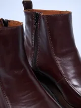 Bota corta de cuero negro, estilo botín chelsea, con puntera cuadrada y suela track gruesa y robusta.