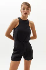 Short de lino negro con cintura alta, pinzas delanteras, bolsillos laterales y cierre frontal con gancho metálico.